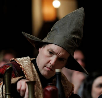 John Harrell in wizard robes and hat and table of vials