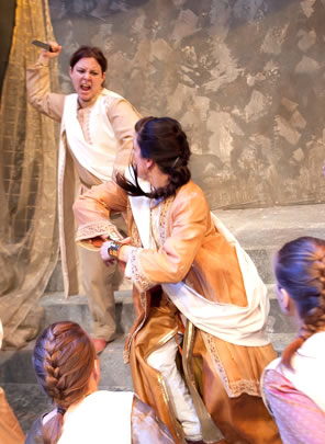 Casca with knife upraised is behind Caesar who is turning and ready to hit Casca with an elbow as two other conspirators in front move in. A curtain around a column and a mottled background are behind.